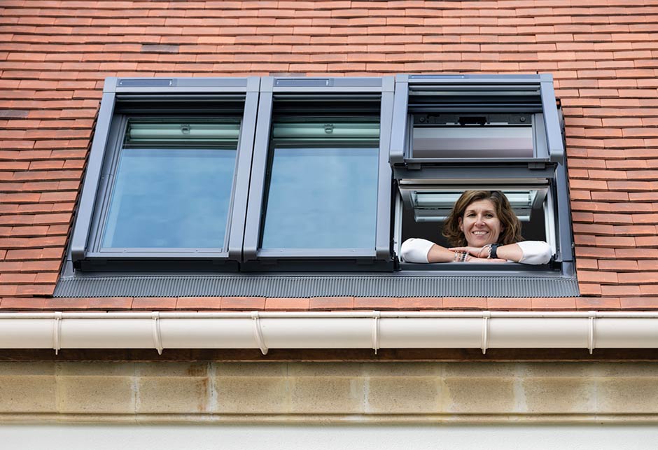woman looking out her roof window