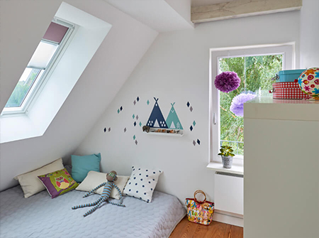 Ein kleines, helles Kinderzimmer mit einem VELUX Dachfenster und einem Dachgaubenfenster.