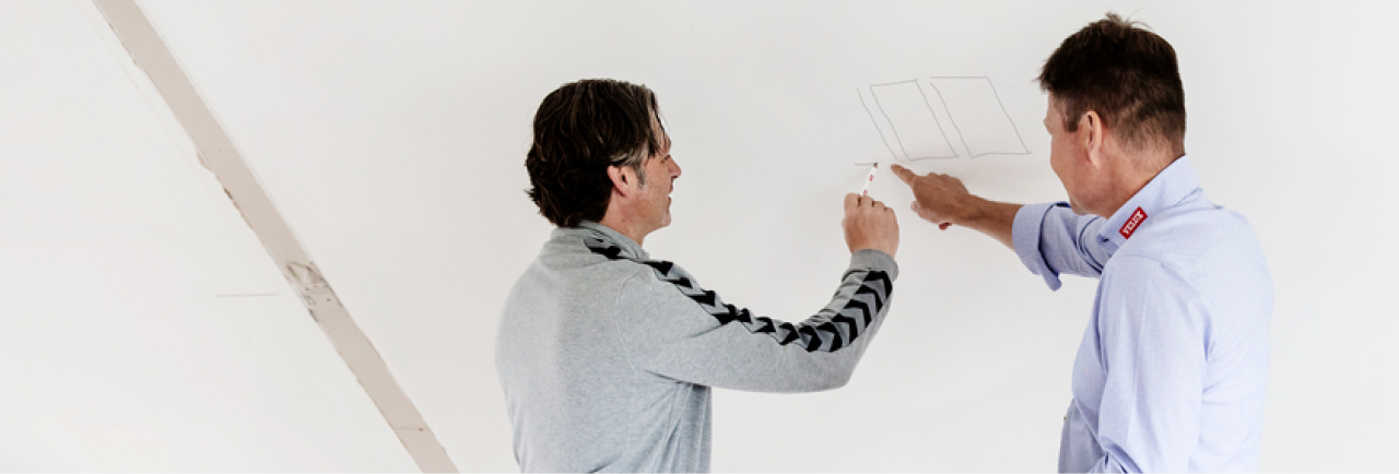 Zwei Männer zeichnen Ideen an die Wand