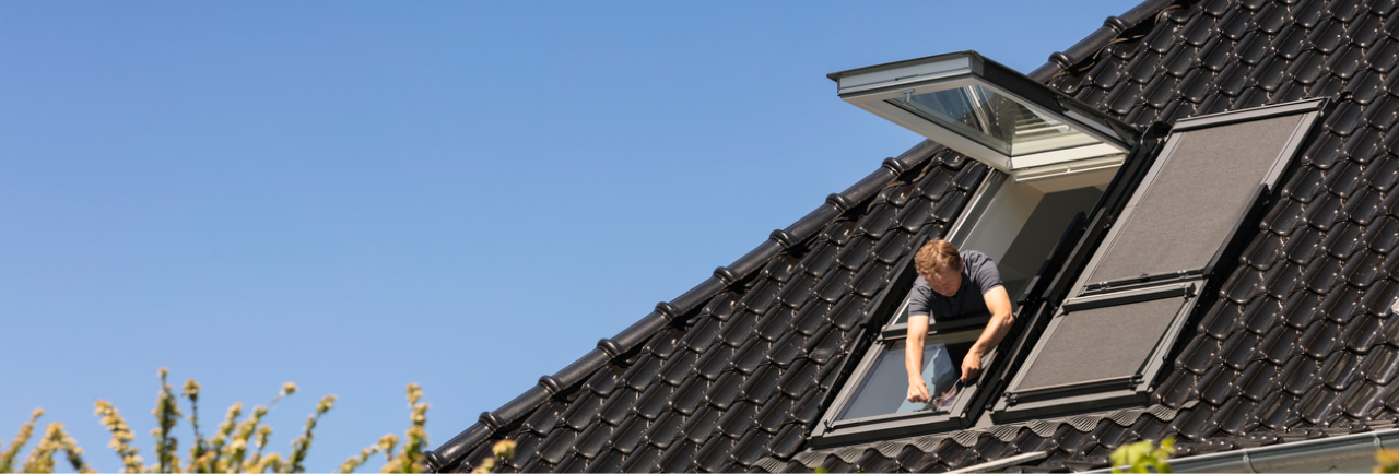 Installatör som installerar ett VELUX takfönster i ett tak med takpannor