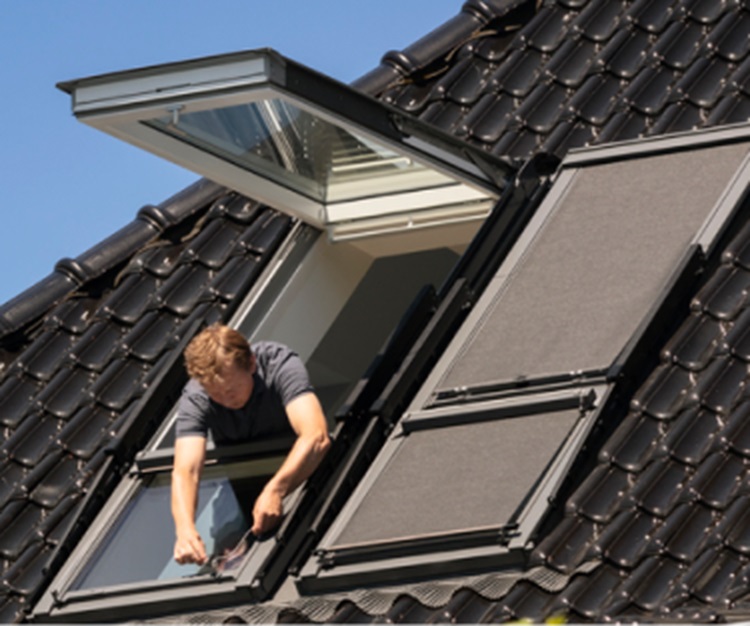 Installatör som installerar ett VELUX takfönster i ett tak med takpannor